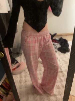 Svart långärmad croppad tröja - Säljer en svart långärmad croppad tröja med v-formad nederkant. Tröjan är figurnära och har en snygg, enkel design som passar perfekt till jeans eller kjol. Materialet känns mjukt och stretchigt, vilket gör den bekväm att bära.