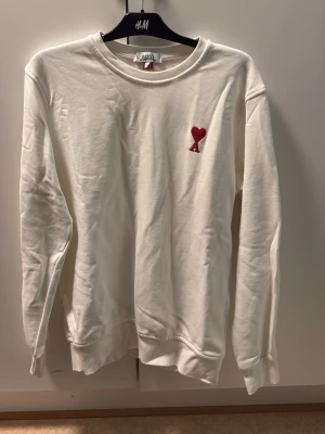 Vit sweatshirt från Ami Paris  - Säljer en stilren vit sweatshirt från Ami Paris i storlek L. Säljer den då det inte är min stil längre , inga fläckar utan jätte fint skick 