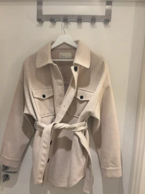 Beige kappa - Säljer denna kappa från Nelly. Använd gå gånger så är i bra skick