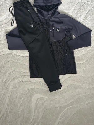 Svarta HUGO mjukisbyxor Sportwear S - Säljer ett MJUKIS tracksuit från HUGO, med en fantastisk blandning av färgerna mörkblå och svart, med lite vita detaljer vid dragkedjor osv. tracksuitet är i helt nyskick och har alldrig används. 