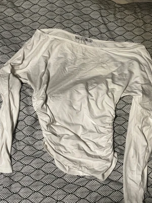 Vit långärmad topp från 157 - Säljer en vit långärmad topp från 157 i storlek XS. Modellen har offshoulder-skärning och är gjord i mjuk bomull, perfekt för dig som gillar enkel och clean stil. Passformen är normal och tyget är tunt och skönt mot huden.