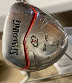 Spalding SP99 golfklubba 1HL - Spalding SP99 1HL golfklubba med 460cc huvud, hot forged teknik och svart/röda detaljer. Skaftet är i high modulus graphite med Flex R och greppet är svart med vita linjer. Perfekt för dig som vill ha en snygg och stabil driver på banan.