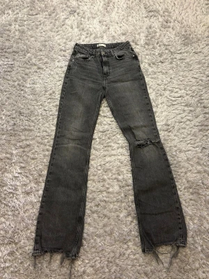 Gråa jeans från Ginatricot  - Gråa jeans från Ginatricot med hål i och i storlek 36. 