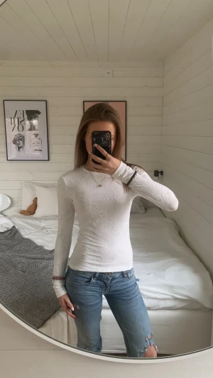Vit långärmad topp med  mönster - Säljer en vit långärmad topp från Bik Bok i storlek XS. Toppen har ett diskret mönster i strukturen och är figurnära med rund hals. Materialet känns mjukt och stretchigt, perfekt att styla med jeans. Supersnygg och enkel att matcha! 💋