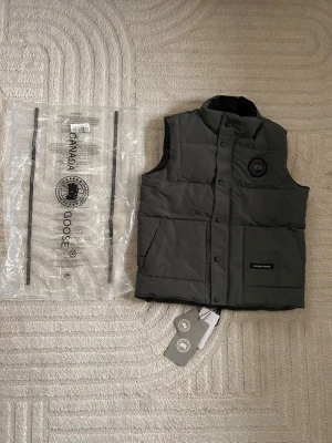Canada goose väst  - Säljer nu en fin väst ifrån Canada Goose. Helt ny och oanvänd. Endast testad. Säljes då den inte passade mig. Storlek M men sitter som en S. Är du mellan 170-176 Cm lång så kommer den att passa perfekt.