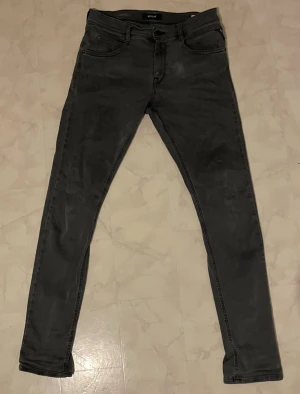 Replay svarta jeans - Svarta jeans från Replay med skinny passform och klassisk femficksdesign. Jeansen har en mörk tvätt och raka bakfickor med Replay-söm. Materialet är stretchigt jeans för en bekväm känsla. Perfekt för dig som gillar en smal siluett.