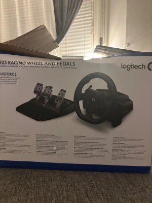 Logitech G923 Racing Wheel and Pedals - Logitech G923 Racing Wheel och pedaler med TrueForce force feedback för realistisk racingupplevelse. Komplett set med ratt, pedaler och växelspak. Produkten ser ut att vara i gott skick med minimalt slitage. Perfekt för simracing på PC och konsol.