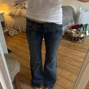 Lågmidjade bootcutjeans - Så fina lågmidjade bootcutjeans. Köpt de vintage men aldrig använt. Har något som ser ut som en slitning i grenen (sista bild) men skulle gissa på att det är en lagning för det är ingen slitning. Jag är 161. Midja 40 cm, innerbenslängd 75 cm. Strl S/M. 