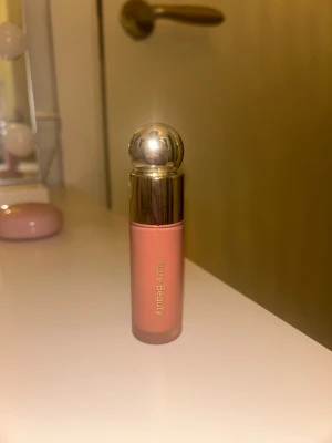 Rare Beauty flytande rouge Bliss - Säljer en flytande rouge från Rare Beauty i färgen Bliss. Kommer i en snygg rosa förpackning med guldig rund topp. Perfekt för att få en fräsch och naturlig look med mjuk rosa ton. Enkel att applicera med applikatorn och smälter fint in i huden. Ganska mycket kvar - men ej full (därav pris). Väl omhändertagen.💕