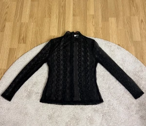 Svart spetsblus från By Malina - Supersnygg svart spetsblus från By Malina med hög hals. Säljer den då den inte riktigt är min stil längre, nypris är 1600. Pris går att diskutera❤️
