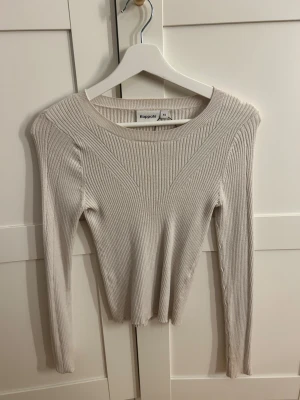 Ribbad beige tröja från Kappahl - Snygg ribbad tröja från Kappahl i beige färg, storlek XS. Tröjan har långärmad design och rund halsringning, med en slim passform som sitter riktigt nice. Perfekt att styla med jeans eller kjol för en clean look.