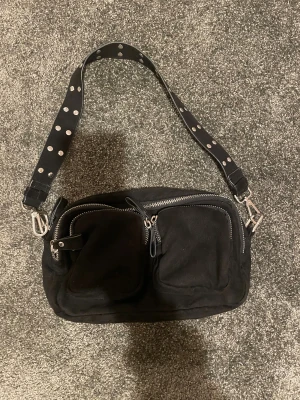 Snygg svart handväska  - En snygg väska från gina med silver knappar