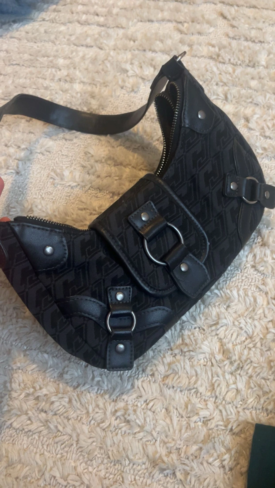 Svart axelväska med mönster och detaljer