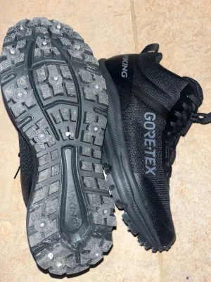 Svarta Viking Gore-Tex kängor - Säljer ett par svarta Viking kängor med Gore-Tex membran och grov mönstrad sula med dubbar för extra grepp. Skorna har snörning och är tillverkade i syntetmaterial med robust design, perfekt för utomhusaktiviteter under höst och vinter. Har använt 2 gånger bara helt nya och kommer med box ! Pris kan diskuteras!