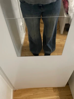 Blå wide jeans med hög midja - Säljer ett par blå jeans med breda ben och hög midja. Jeansen har klassisk femficksdesign och är tillverkade i jeansmaterial. Snygga sömmar framtill och en cool, avslappnad passform som ger en modern vibe.