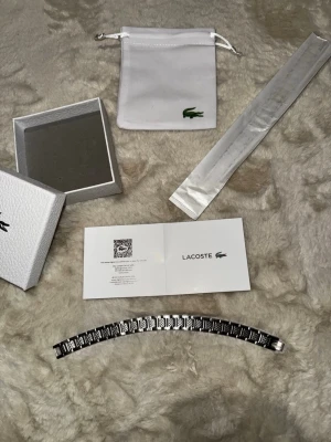 Lacoste silverfärgat armband - Lacoste Armband med all tillbehör på bilden