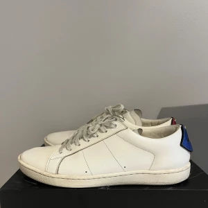 Saint Laurent lip  - Säljer mina saint Laurent lips sneakers. Skorna är i grymt skick och är i princip som nya. Det är storlek 41 men jag skulle säga att det sitter lite större så även om man har 41,5. Man får bara skorna. Skorna är självklar helt äkta. Nypris 7000kr vårt pris 1200!🤝🤩 Bara att skriva vid minsta lilla fundering:)             //ds resell