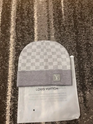 Grå rutig mössa  - Snygg grå mössa med klassiskt rutigt mönster och uppvikt kant. Mössan är tillverkad i mjukt material som känns lyxigt. Perfekt för dig som gillar exklusiva accessoarer med stilren design. All info finns vid svarta annonsen, här av er vid frågor:)