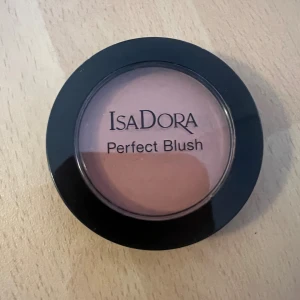 IsaDora Perfect Blush Frosty Rose - IsaDora Perfect Blush i nyansen 64 Frosty Rose. Kommer i en rund svart dosa med transparent lock. Färgen är en mjuk, rosad ton som ger en naturlig fräschör till kinderna. Innehåller 4,5 g och är doftfri samt kliniskt testad.