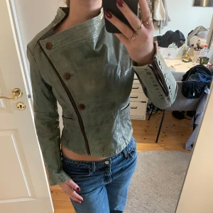 Grön skinnjacka från Frontrow Living - Unik vintage Frontrow Living skinnjacka 💞 Äkta skinn och 100% bomulls lining Skinnjackorna på deras hemsida ligger på ca 4500kr Coola nit-detaljer på ärmarna Jättefint skick
