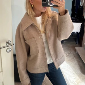 Så fin höstjacka - Skitsnygg kortare kappa / jacka med dragkedja och knappar. Perfekt nu till hösten i så fin beige färg 🩷Den är nopprig och kan noppras av med maskin/rakblad, men inget man tänker på när man har på sig den!