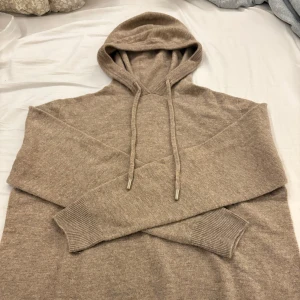 Beige stickad hoodie med huva - Ganska ny, med en väldig fin färg att kunna matcha med jeans nu till höst vädret. Bra och nytt skick använd ungefär 3-4 gånger. Säljs på grund av att storleken inte passade min så bra. Priset kan prutas.
