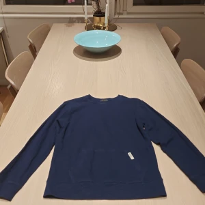 Mörkblå tröja från Polo Ralph Lauren - Snygg mörkblå tröja från Polo Ralph Lauren i storlek L. Tröjan har rund halsringning, långa ärmar och en klassisk, enkel design. Tillverkad i mjuk bomull som känns skön mot huden. Perfekt för dig som gillar stilrena och tidlösa plagg.
