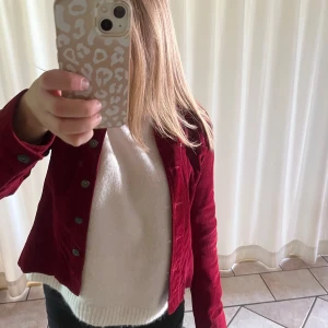 Röd manchesterjacka från Hennes, 36 - Snygg röd manchesterjacka från Hennes i storlek 36. Klassisk jeansjacke-modell med knappar framtill, krage och långa ärmar. Jackan har en cool, djup röd färg och är perfekt för dig som vill sticka ut lite extra.