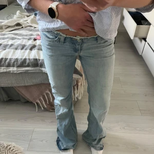 No waist jeans nelly (NYSKICK)  - Snygga ljusblå jeans från Nelly med bootcut passform och rå, fransad midja. Klassisk femficksmodell med dragkedja och knapp framtill. Jeansen är tillverkade i mjuk denim och har en avslappnad vibe som passar perfekt till sneakers. Använda 1 gång, säljer då de är för långa. 
