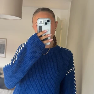 Blå stickad tröja från JDY med snörning - Säljer en blå stickad tröja från JDY i storlek S. Tröjan har vita snörningsdetaljer längs axlar och ärmar, rund halsringning och långa ärmar. Perfekt för dig som vill ha en  mysig och snygg look med lite edge. Skriv för mer info 💕