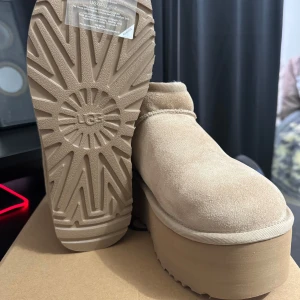Uggs Classic Mini Platform “sand” - Aldrig använda, nya i kartong färg ”sand” Storlek 37, fraktar och kan mötas upp. Kvittot är kvar.
