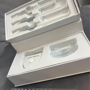 Nice Smile Whitening Kit - Komplett Nice Smile Whitening Kit för tandblekning hemma. Innehåller LED-enhet, munskydd och flera sprutor med blekgel. Produkten äroanvänd och levereras i originalförpackning. Perfekt för dig som vill få vitare tänder snabbt och enkelt. Nytt pris 1000kr.