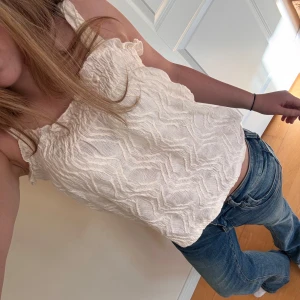 Vit strukturerad linnetopp från Kappahl - Supersöt vit linnetopp från Kappahl med smala axelband och vågig struktur i tyget. Jättefin och i bra skick i stolen 158/164