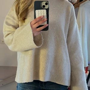 Beige stickad tröja med slits - Mysig beige stickad tröja med breda ribbade muddar och slits i sidorna. Enkel och stilren design som passar till jeans eller kjol. Använd ett fåtal gånger🩷