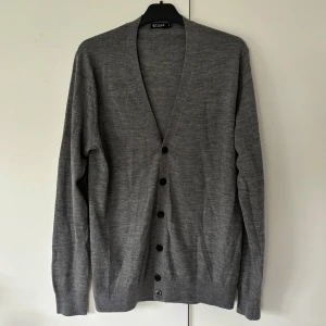 Tiger of Sweden kofta - Eftertraktad Tiger of Sweden grå stickad kofta i nyskick och storlek M. Den snyggaste koftan jag personligen har ägt då passformen är helt klockren och den är väldigt elegant och snygg på. Går ej att få tag på längre och väldigt skönt tyg. Passar till allt och perfekt nu till vinterhalvåret dessutom. Tveka inte vid minsta fråga eller fundering! 