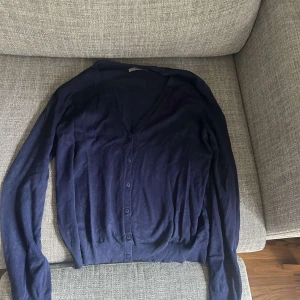 Mörkblå kofta  - En stilren mörkblå kofta från Anna Field med v-ringning och knappar framtill. Långärmad och i mjukt, tunt material.