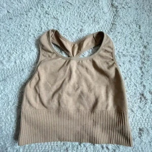 Beige ribbad linnetopp med korsrygg - Tränings topp i färgen beige, storleken på har gått bort men den ska vara i storlek S hade kanske också funkat på M om man vill att den ska sitta tajt!. Den är köpt på Lager 157.  Jag finns tillgänglig i Skövde, Borås & Värnamo om ni vill mötas istället för att betala frakt🙈❤️🥰