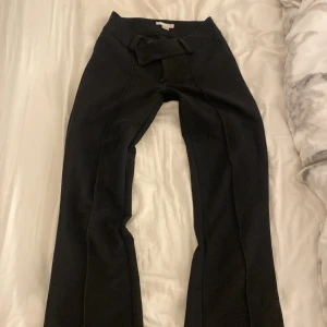 Svarta byxor från Gina Tricot - Svarta byxor från Gina Tricot. Byxorna är booucut och har inga fickor bak och ger en stilren look som passar till många olika outfits. Mjukt och bekvämt material, perfekta för dig som gillar enkel men trendig stil.