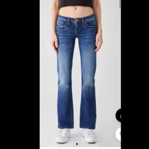 Blå bootcut jeans från LTB - Snygga blå bootcut jeans från LTB, modell Valeria. Jeansen har låg midja, klassiska fem fickor och lätt slitna detaljer framtill.   Jag har råkat riva upp ett av uppslitningarna så hålet har blivit lite större men de är bara en fin detaljSTORLEK 26/32