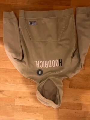 Beige Tracksuit från Hoodrich XL - Säljer en beige hoodie från Hoodrich i storlek XL barn eller Xs man. Hoodien har stor vit och svart logga på bröstet, huva och magficka. Mjukt material med fleece på insidan, ribbade muddar och tryck även på ryggen och ärmen. Perfekt för chill och streetwear. Passar dig mellan 160-168. Priset kan diskuteras.