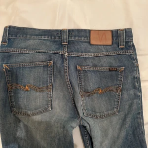 Nudie jeans - W32 L36. Modell Grim Tim. Hål på knäet.