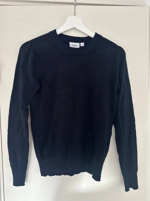 Stickad tröja  - Tunn stickad tröja med fina detaljer vid axlar, handleder och nedtill. Tröjan är från Åhléns märke saint tropez och är använd fåtal gånger! Toppskick