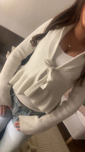 Vit stickad kofta med knyt - Superfin vit stickad kofta med knyt framtill och långa ärmar. 