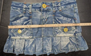 Blå jeanskjol med volang från Only - Säljer en kort jeanskjol från Only med cool tvättad look och volang nedtill. Kjolen har flera fickor, snygga gula knappar och kontrastsömmar i orange och grönt. Perfekt för dig som gillar streetstyle och denim. Märke syns på knapp och etikett.