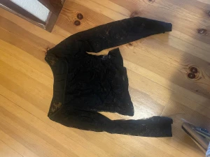 Svart spets tröja - Säljer en svart långärmad spets tröja från SHEIN i storlek XS. Tröjan är helgjord i genombruten spets med rund hals och figurnära passform. Perfekt för dig som gillar detaljer och vill ha en snygg topp med lite edge.