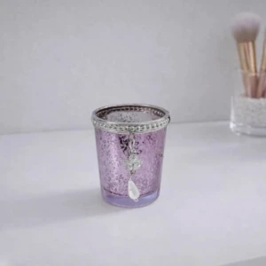 Liten lila ljushållare med dekorativt ängelhänge - bra skick - En liten lila ljushållare med ett dekorativt ängelhänge. Ljushållaren är sparsamt använd och i fint skick. Det finns små, knappt synliga skav, vilket syns lite på bilderna, men inget som påverkar helhetsintrycket. En söt inredningsdetalj som passar perfekt för mysiga kvällar eller som en fin present! FÖRST TILL KVARN!