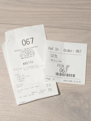 #67 McDonald's kvitto - Två papper från McDonald's, ett kvitto och en orderlapp med nummer 067. På kvittot står det bland annat Big Mac, Dubbel Cheeseburgare och McFlurry Oreo. Båda lapparna är vita med svart text och har tryckt information om beställningen.