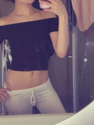 Svart offshoulder croppad topp - Trendig svart offshoulder topp som är croppad och sitter tight. Perfekt för dig som gillar en stilren och enkel look. Toppen är ärmlös och har en snygg passform som framhäver axlarna.