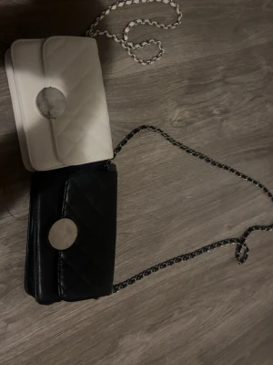 Svart och vit quiltad axelväska - Köp båda för 200 kr!!den vita har några skador där framme som man kan se i bilden