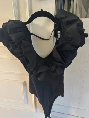 Svart volangbody Zara - Populär body från Zara med volanger. Nyskick.